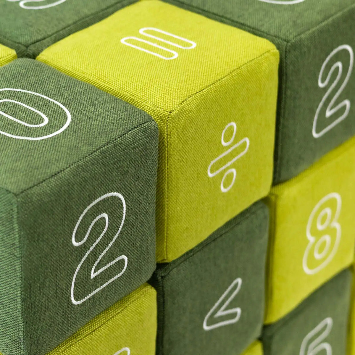 JOLLY HEAP Numo – Detail von Stoff, Nähten und aufgestickten Zahlen und Rechenzeichen